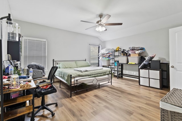 bedroom featuring vaulted ceiling, light wood-style flooring, and a ceiling fan