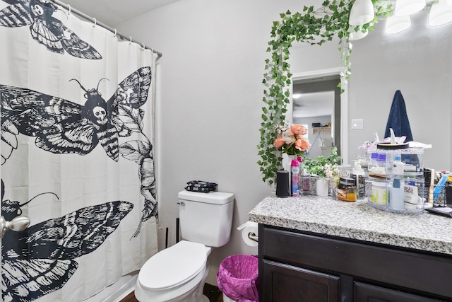 bathroom with toilet, curtained shower, and vanity