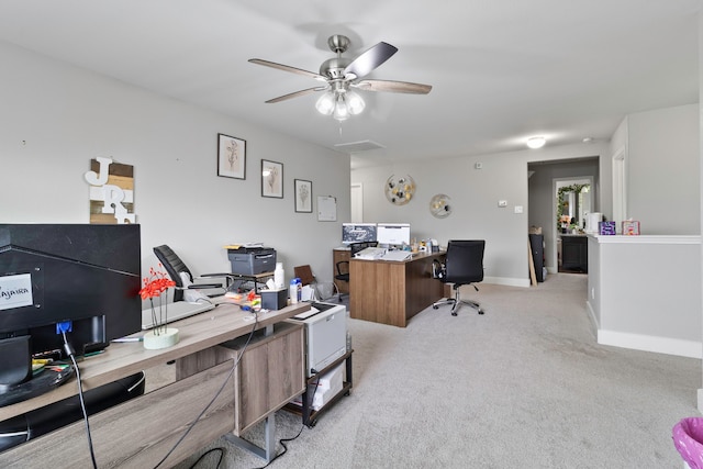 carpeted office featuring baseboards and a ceiling fan