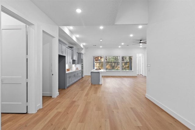 kitchen with light wood finished floors, recessed lighting, gray cabinets, light countertops, and baseboards