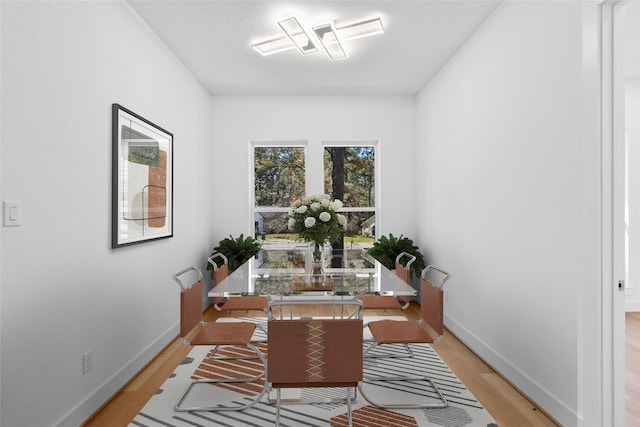 dining room featuring light wood-style flooring and baseboards