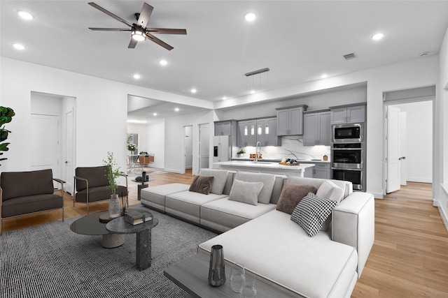 living room featuring light wood-type flooring and recessed lighting