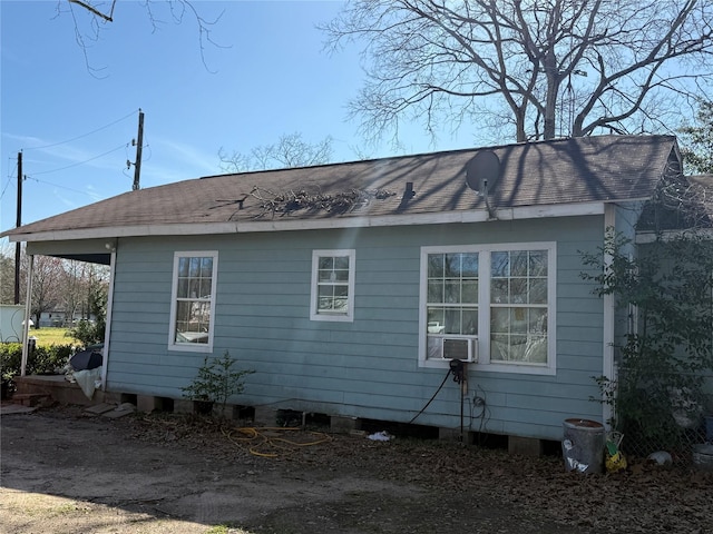 view of home's exterior featuring roof with shingles and cooling unit