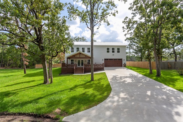 split foyer home with a garage, concrete driveway, metal roof, fence, and french doors