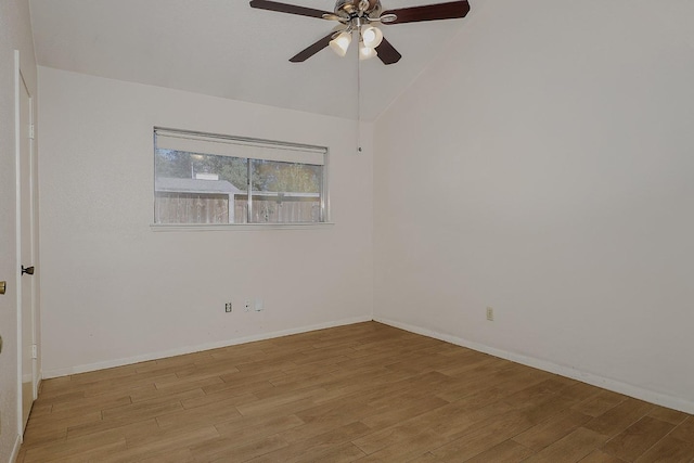 empty room with lofted ceiling, light wood-style flooring, baseboards, and ceiling fan