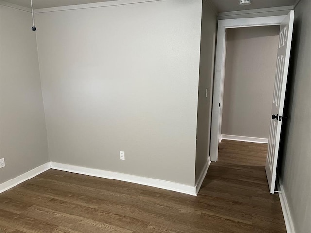 corridor featuring dark wood-style flooring and baseboards