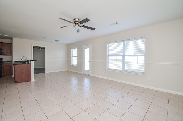 26810 Blacktail Ct, Hockley, TX 77447 - unfurnished living room with light tile patterned floors, visible vents, baseboards, and a ceiling fan