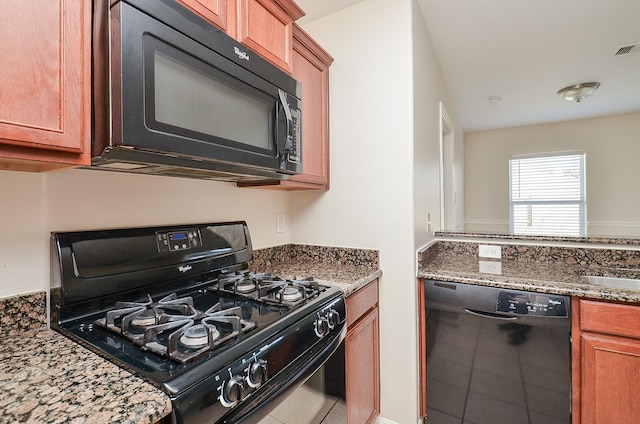 26810 Blacktail Ct, Hockley, TX 77447 - kitchen with tile patterned flooring, black appliances, brown cabinets, and stone countertops