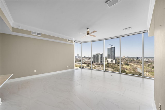 unfurnished room featuring baseboards, visible vents, ceiling fan, a view of city, and floor to ceiling windows