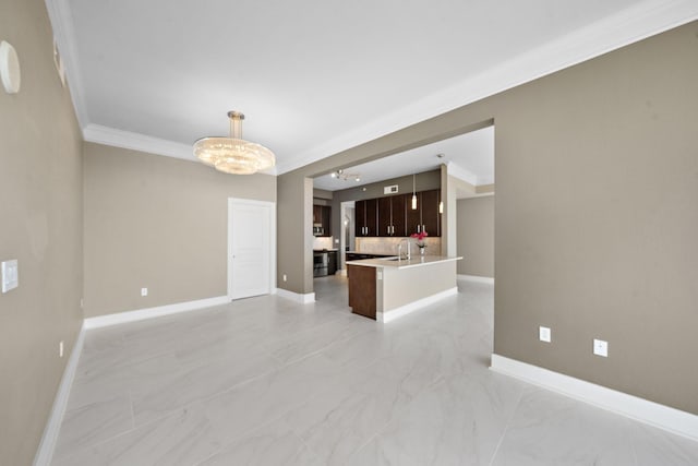 interior space featuring baseboards, open floor plan, marble finish floor, light countertops, and crown molding