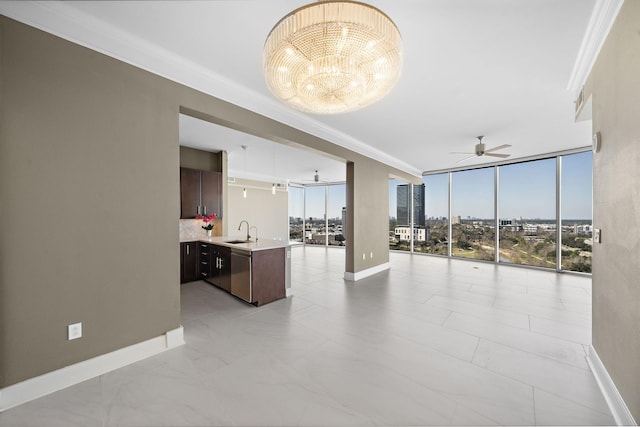 interior space featuring baseboards, ornamental molding, a city view, floor to ceiling windows, and a sink