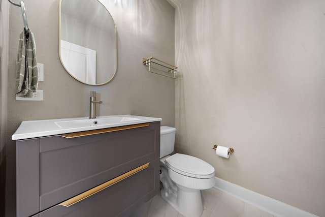 half bathroom with toilet, baseboards, and vanity