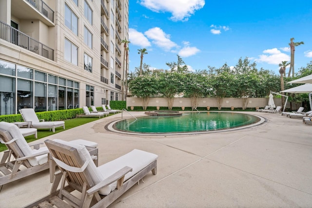 view of pool with a pool with connected hot tub and a patio