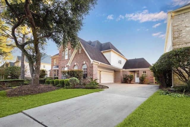 view of front facade with a garage, concrete driveway, brick siding, and a front yard