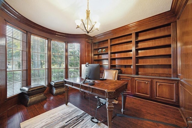 office space featuring a chandelier, dark wood finished floors, built in features, and ornamental molding