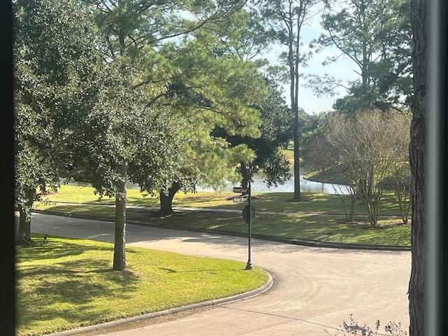 view of community with a lawn and a water view