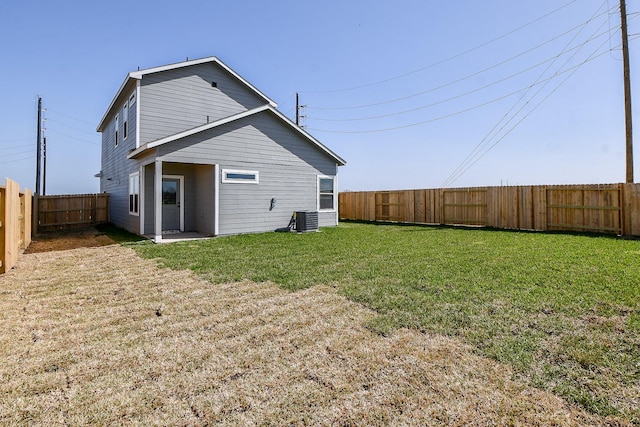 back of property with a yard, cooling unit, and a fenced backyard