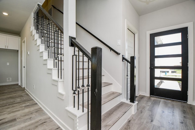 foyer with recessed lighting, light wood-style flooring, and baseboards