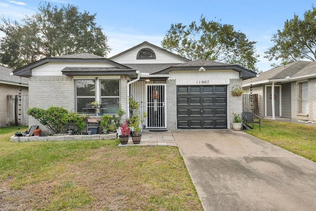 ranch-style home featuring driveway, brick siding, roof with shingles, an attached garage, and a front yard