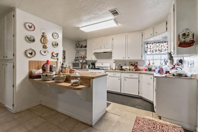 kitchen with a peninsula, under cabinet range hood, white range with gas cooktop, and white cabinets