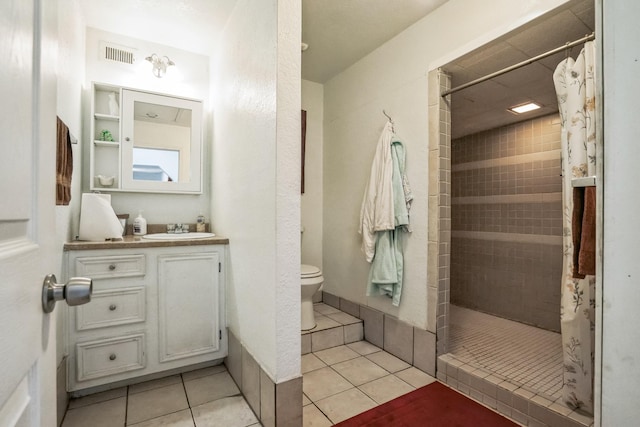 full bath featuring tile patterned flooring, tiled shower, visible vents, and toilet