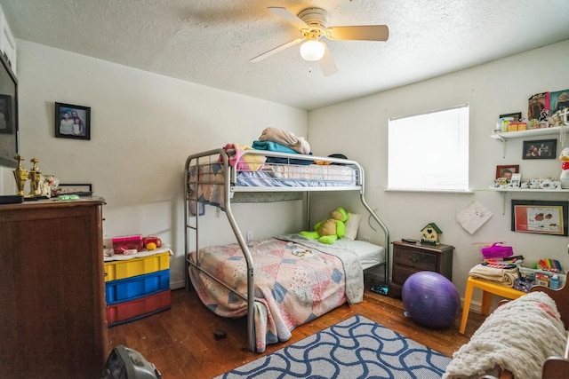 bedroom with a textured ceiling, wood finished floors, and a ceiling fan