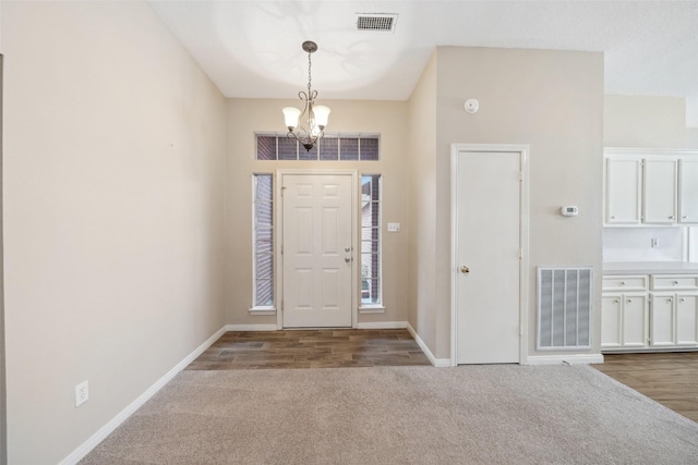 entrance foyer featuring carpet flooring, visible vents, and baseboards