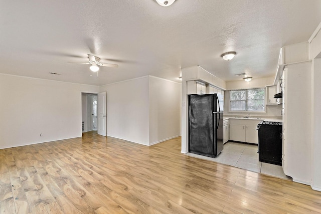 3230 Virginia St, La Marque, TX 77568 - kitchen with open floor plan, gas range, light countertops, and freestanding refrigerator