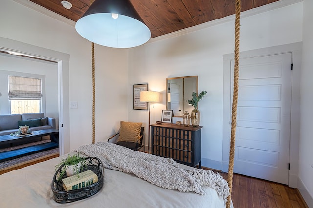 bedroom featuring ornamental molding, wood ceiling, baseboards, and wood finished floors