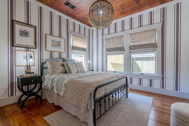 bedroom featuring visible vents, ornamental molding, wooden ceiling, hardwood / wood-style floors, and wallpapered walls