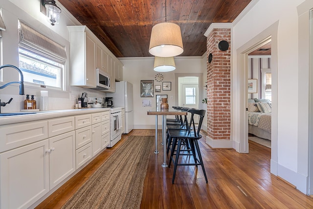 kitchen featuring wooden ceiling, backsplash, white cabinetry, a sink, and white appliances