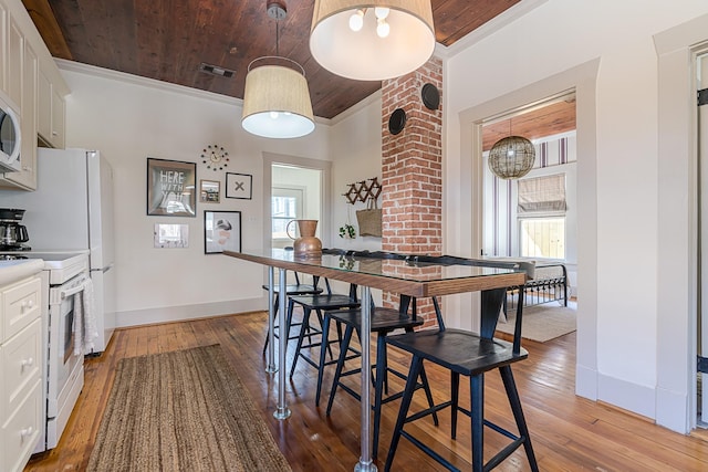 dining room featuring visible vents, ornamental molding, plenty of natural light, and wood ceiling