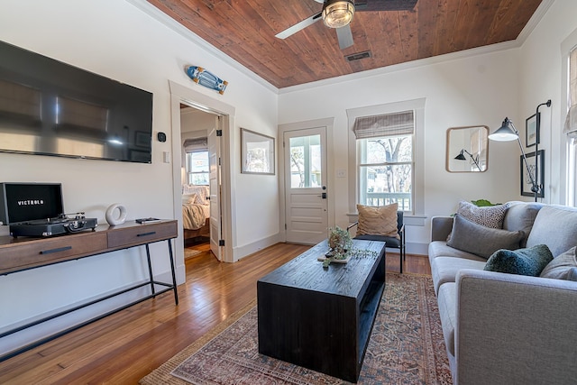 living room featuring wood ceiling, visible vents, wood finished floors, and ornamental molding