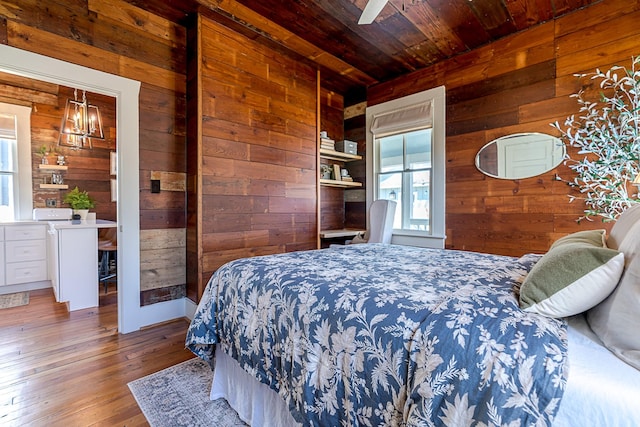 bedroom with wood walls, wood ceiling, and hardwood / wood-style flooring