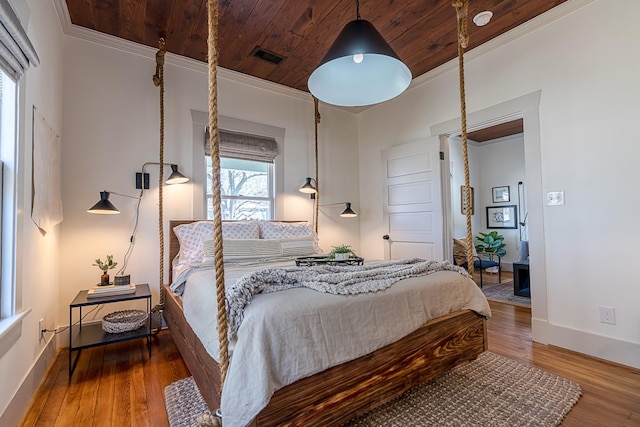 bedroom with ornamental molding, wooden ceiling, baseboards, and wood finished floors