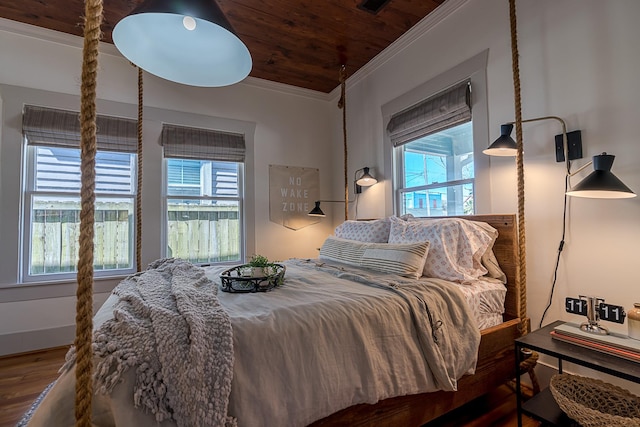 bedroom with wood finished floors, wood ceiling, and crown molding