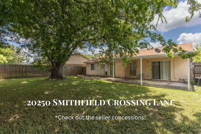 back of house featuring a patio area, a fenced backyard, a yard, and stucco siding