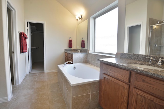 full bath with lofted ceiling, a spacious closet, vanity, a shower stall, and a bath