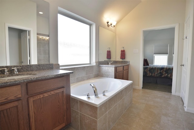 bathroom featuring lofted ceiling, two vanities, ensuite bathroom, a sink, and a bath