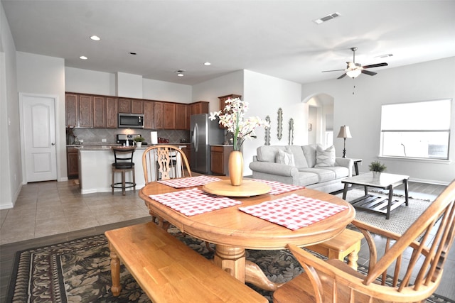 dining space featuring arched walkways, ceiling fan, visible vents, and recessed lighting