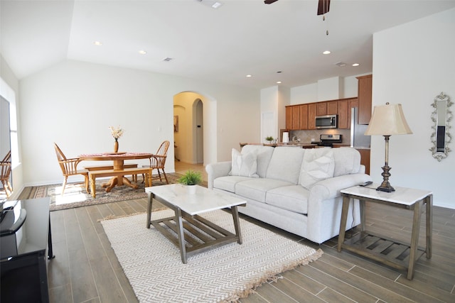 living area featuring arched walkways, lofted ceiling, ceiling fan, dark wood-style flooring, and recessed lighting