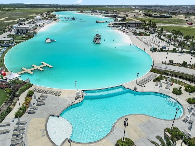 view of swimming pool featuring a patio area and a water view