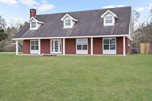 cape cod house with a front yard, fence, french doors, and brick siding