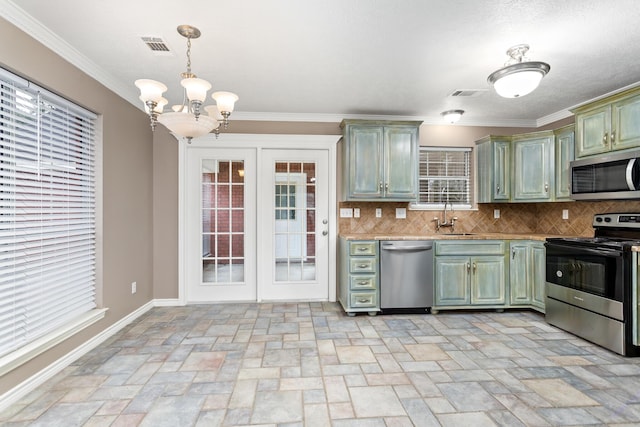 kitchen with visible vents, decorative backsplash, appliances with stainless steel finishes, a sink, and green cabinetry