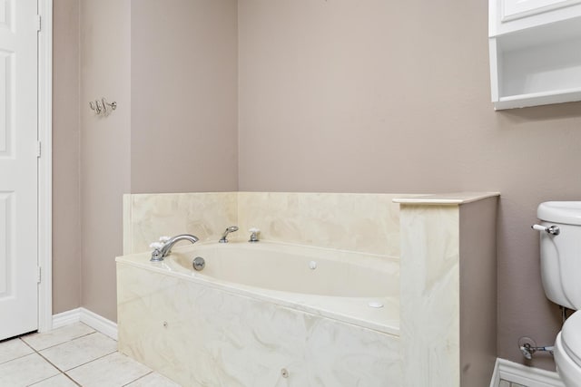 full bath with toilet, a garden tub, baseboards, and tile patterned floors