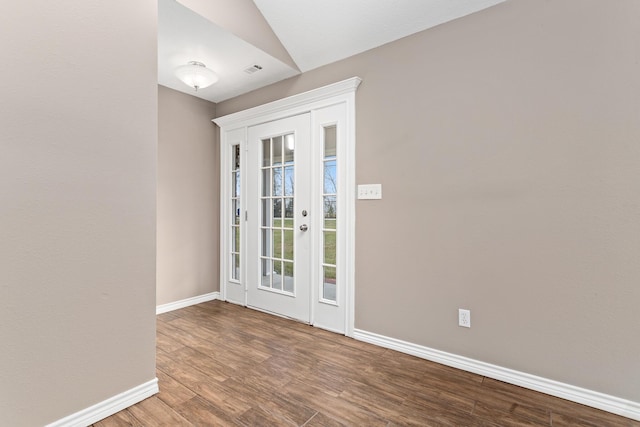 interior space featuring lofted ceiling, wood finished floors, and baseboards