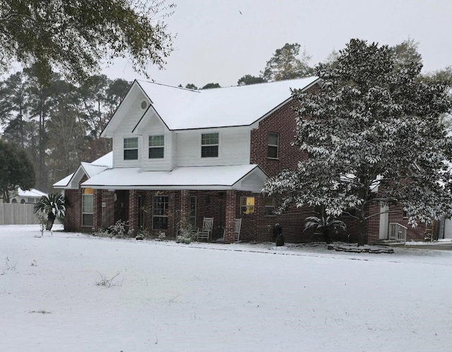 view of front of home with covered porch and brick siding