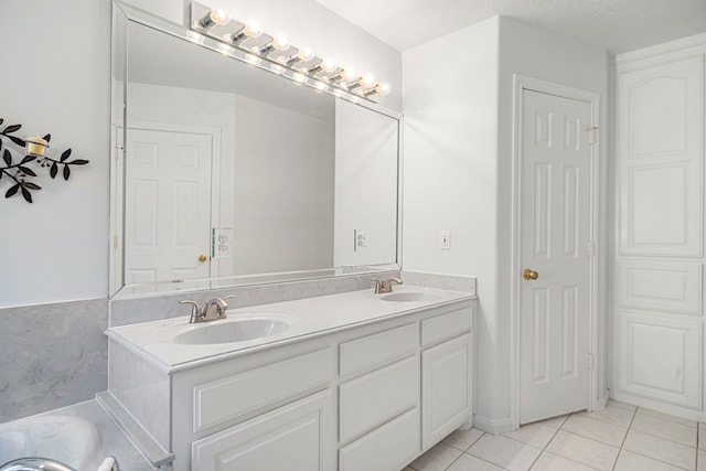 full bathroom featuring double vanity, tile patterned flooring, a sink, and a tub