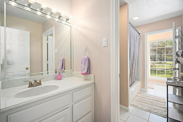 bathroom featuring shower / bath combo, baseboards, tile patterned flooring, a textured ceiling, and vanity