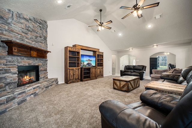 living area featuring carpet floors, arched walkways, visible vents, and a fireplace